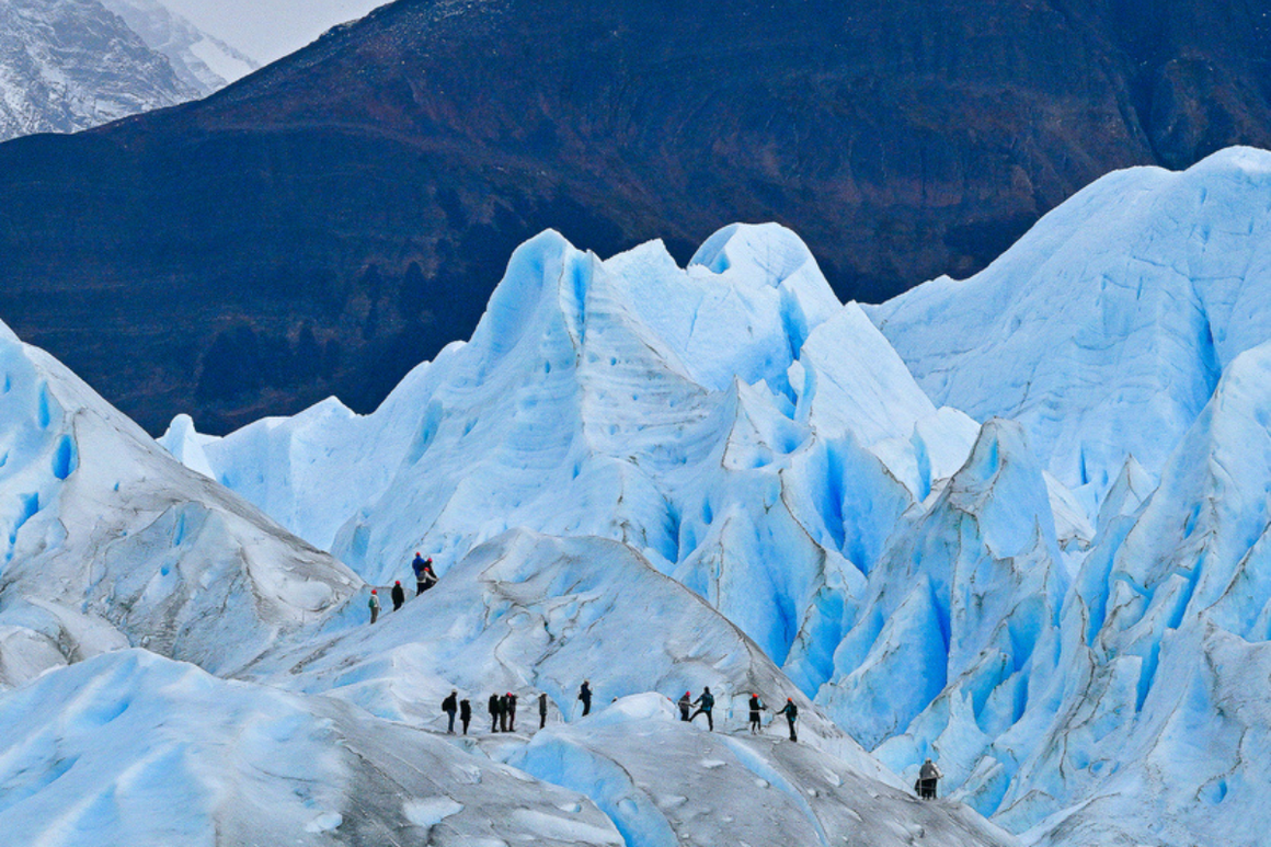 A group of hikers explores the icy expanse of Perito Moreno Glacier in Patagonia, Argentina.
