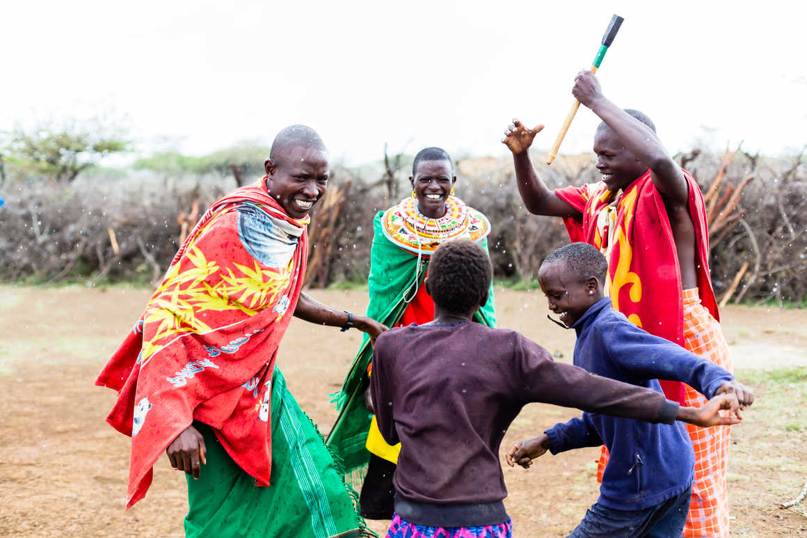 A maasai family dancing in colourful clothes