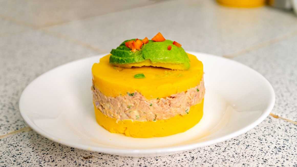 Causa rellena plated with avocado topping