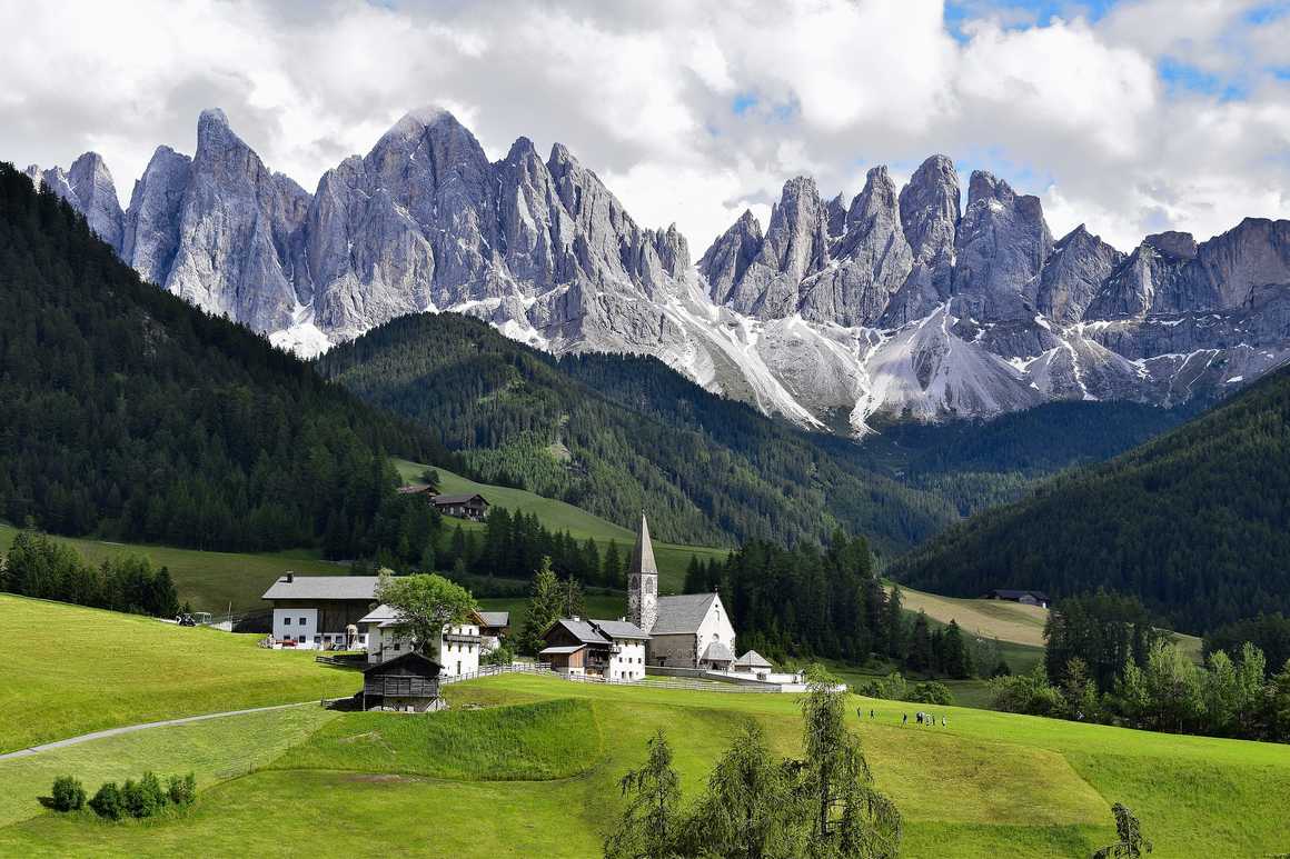 Church in an alpine meadow surrounded by forest and mountains