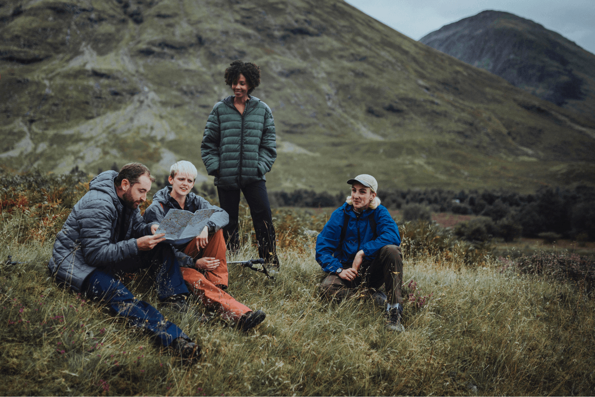 Four trekkers navigating and resting in british mountains/hills