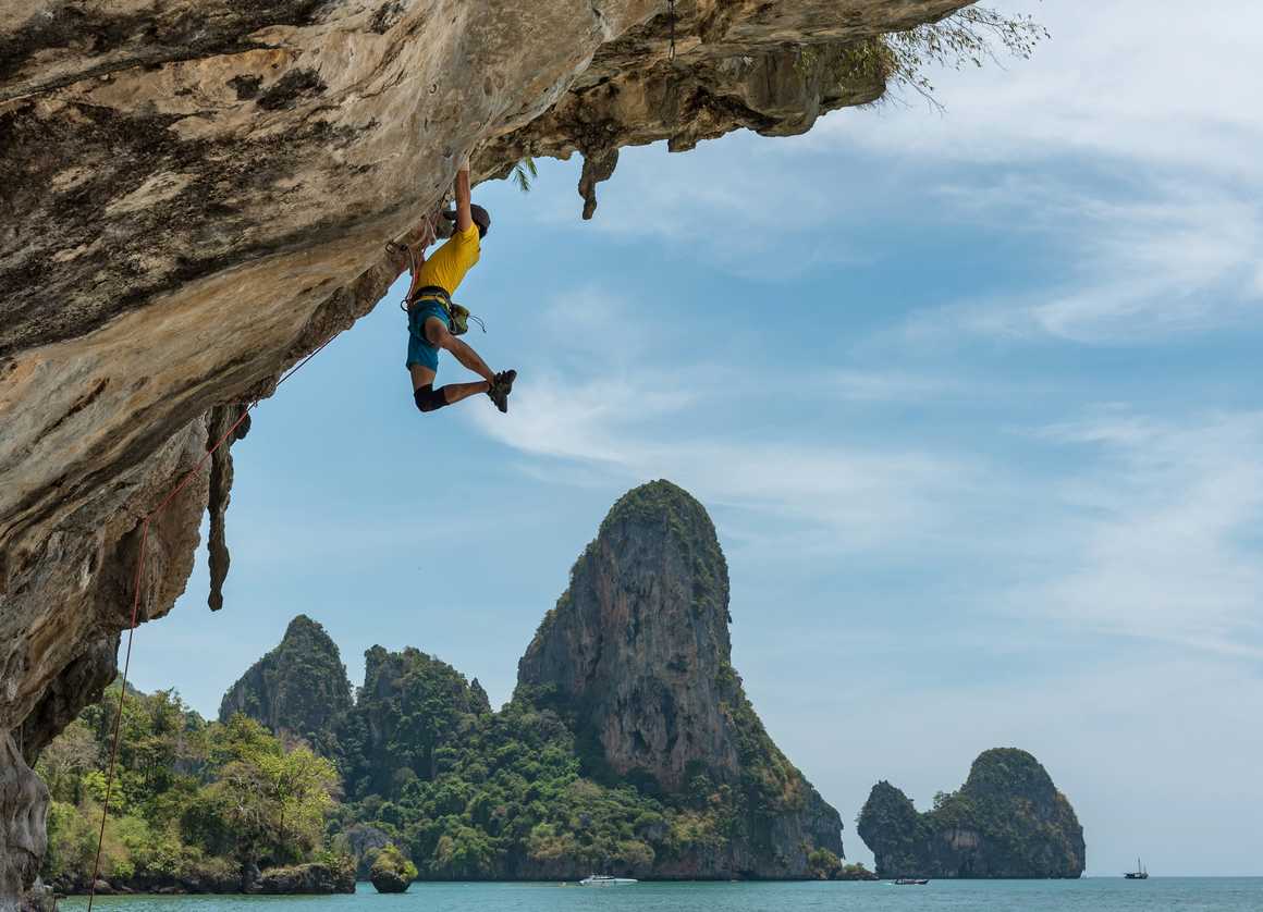 Free climber hanging off a rock in Thailand