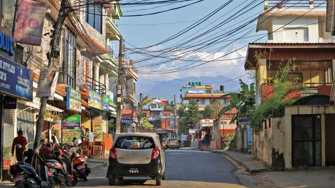 Guest houses built near lakeside with the snow mountain background in Pokhara
