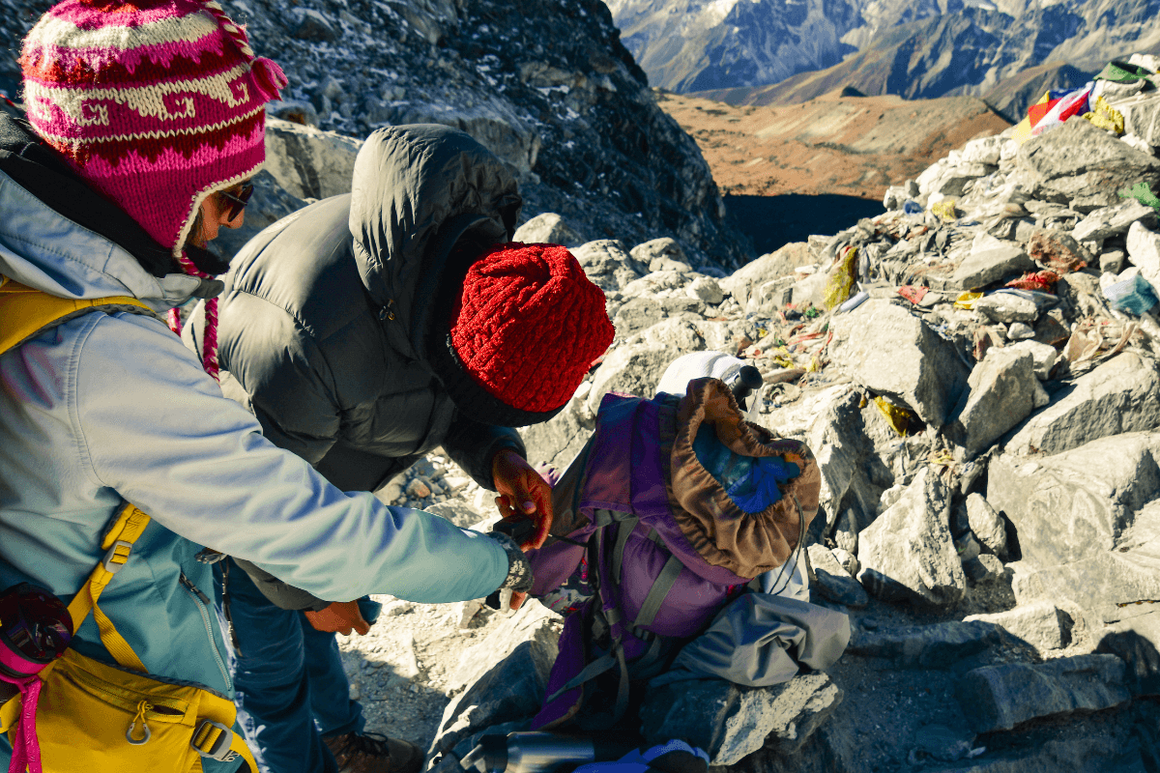 Guide taking the pulse oximeter reading of a hiker in the mountains
