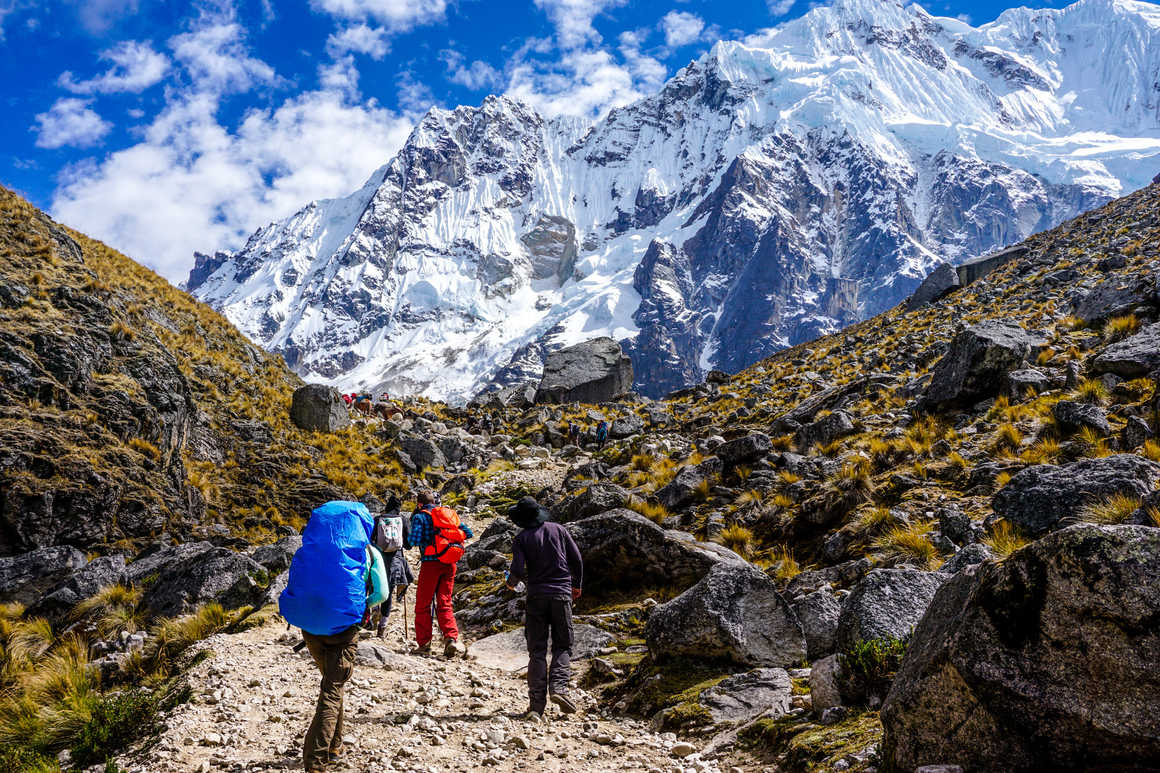 Hikers cimbing in front of the Salkantay glacier