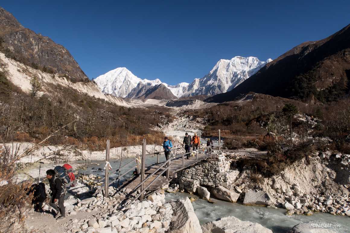 Hikers crossing a bridge during the Manaslu Circuit Trek