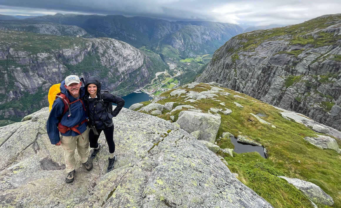 Hikers on the Kjeragbolten trek looking down at the Lysefjord