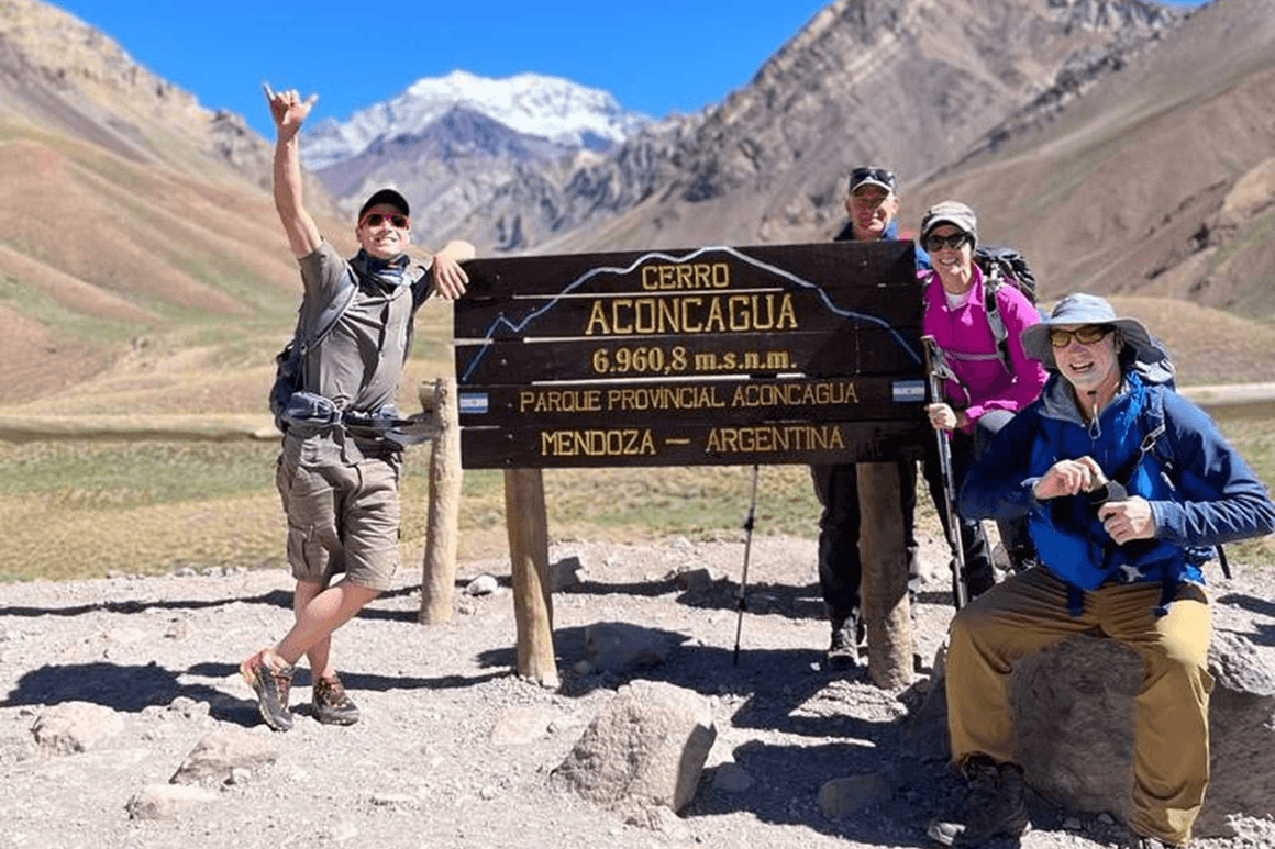 Kandoo hikers posing by the Cerro Aconcagua sign
