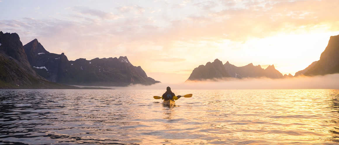 Kayaker in the water in the Lofoten Islands