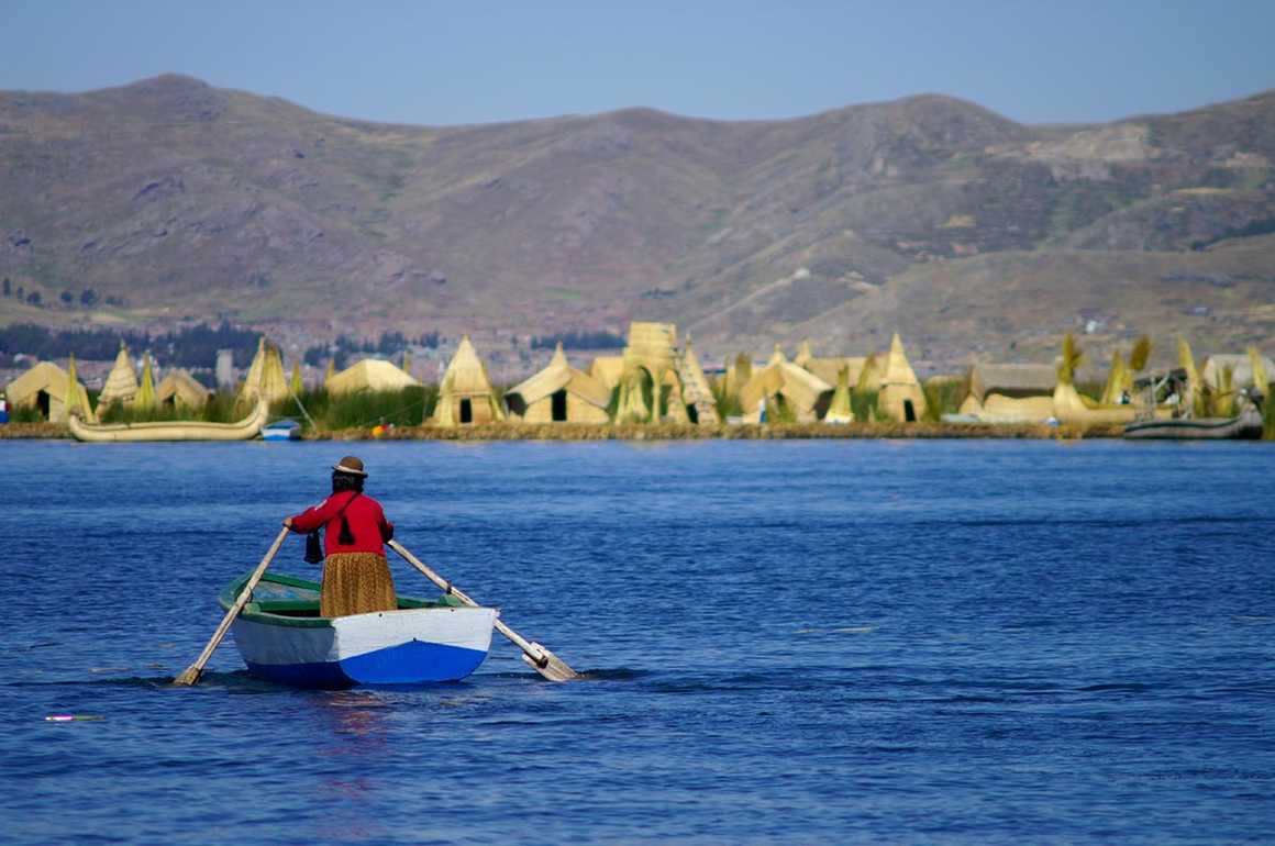 Peruvian woman navigating on Titicaca lake
