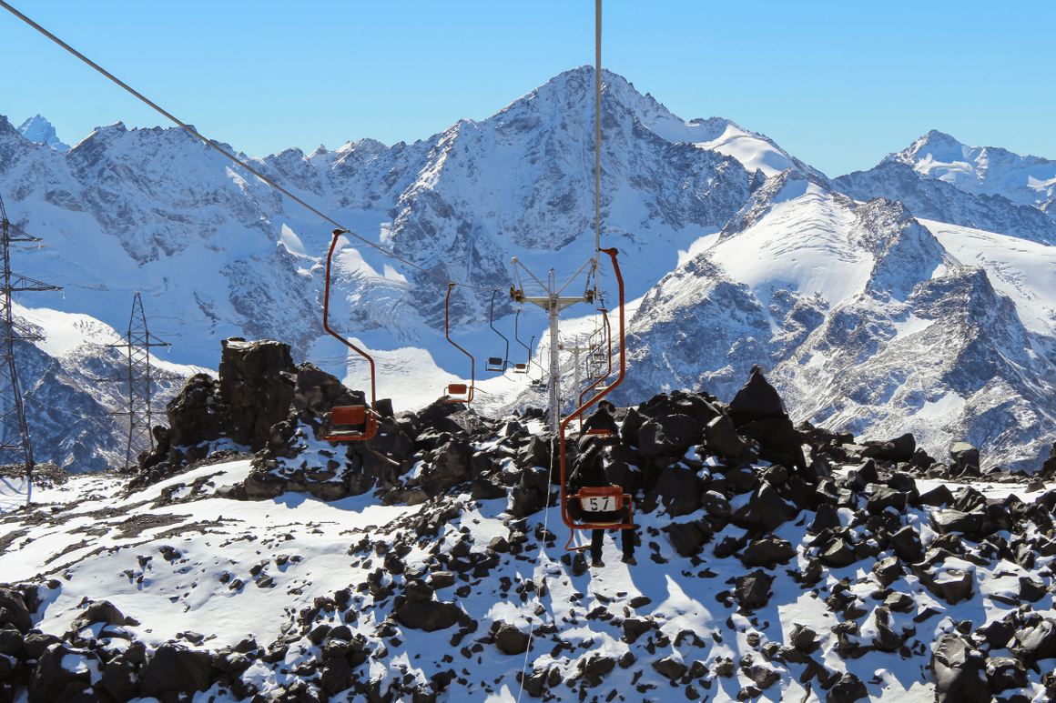 Snowy mountains in distance and ski lift