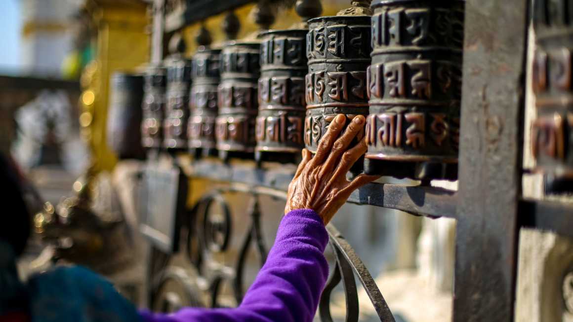 Someone touching the prayer wheels of Swayambhunath Stupa