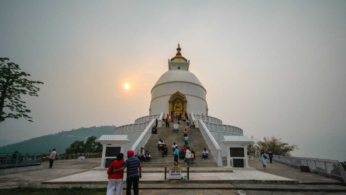 Sun shinng through cloud behinmd the shanti stupa in Pokhara