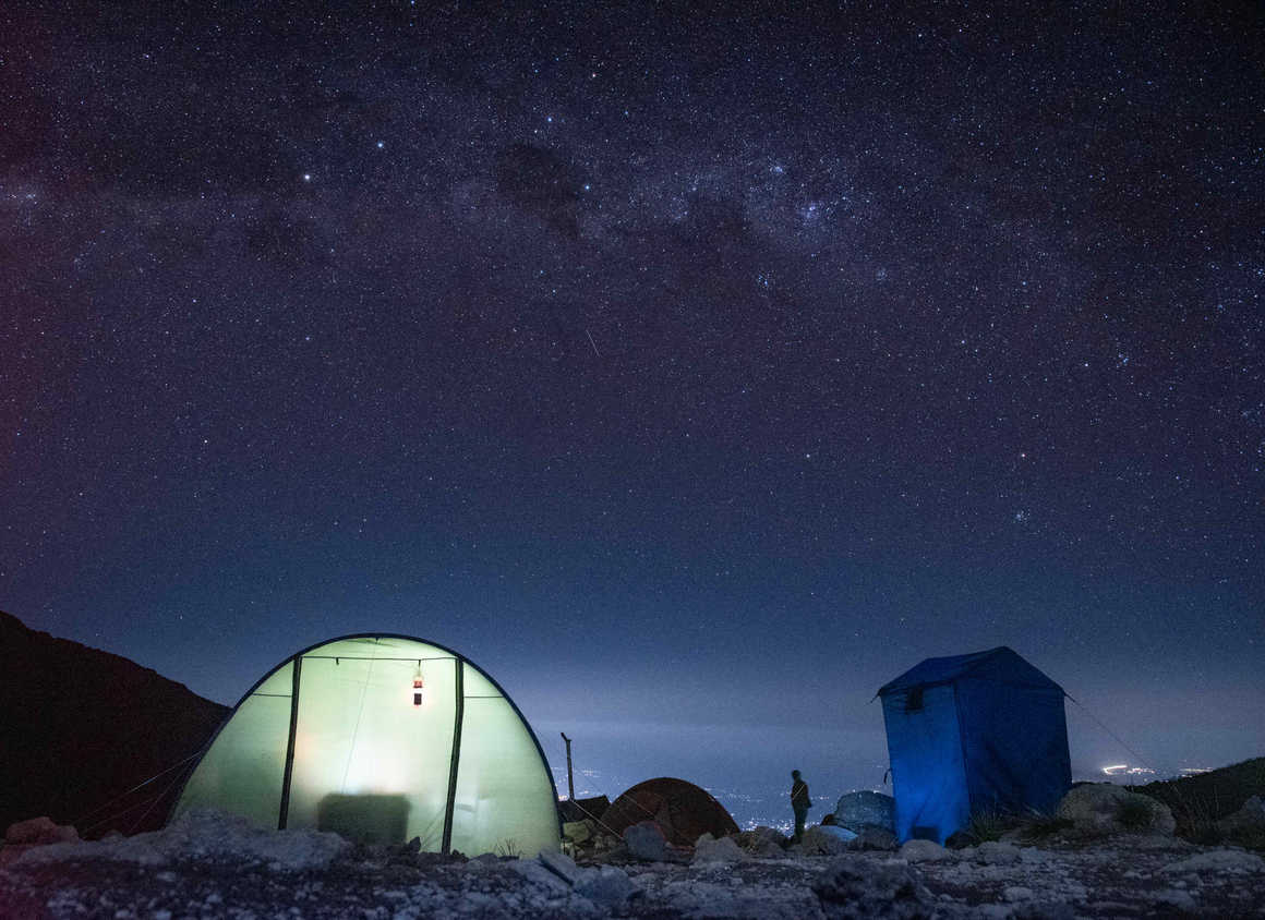 The starry night sky above and Moshi town below on Kilimanjaro