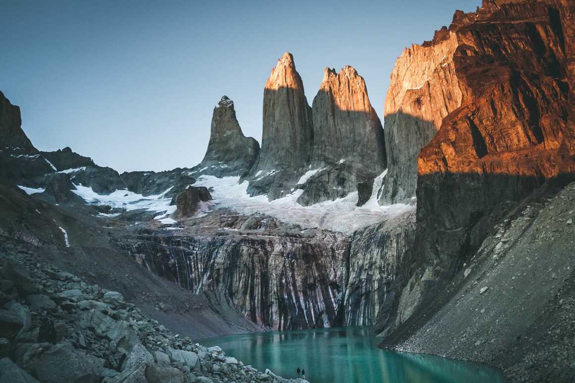 three spires of Cerro Torre in Patagonia overlooking a lake
