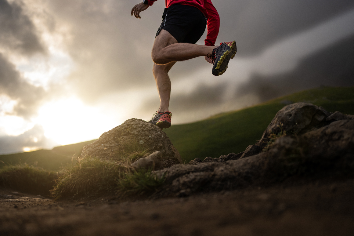 Trail runner running over rocky terrain