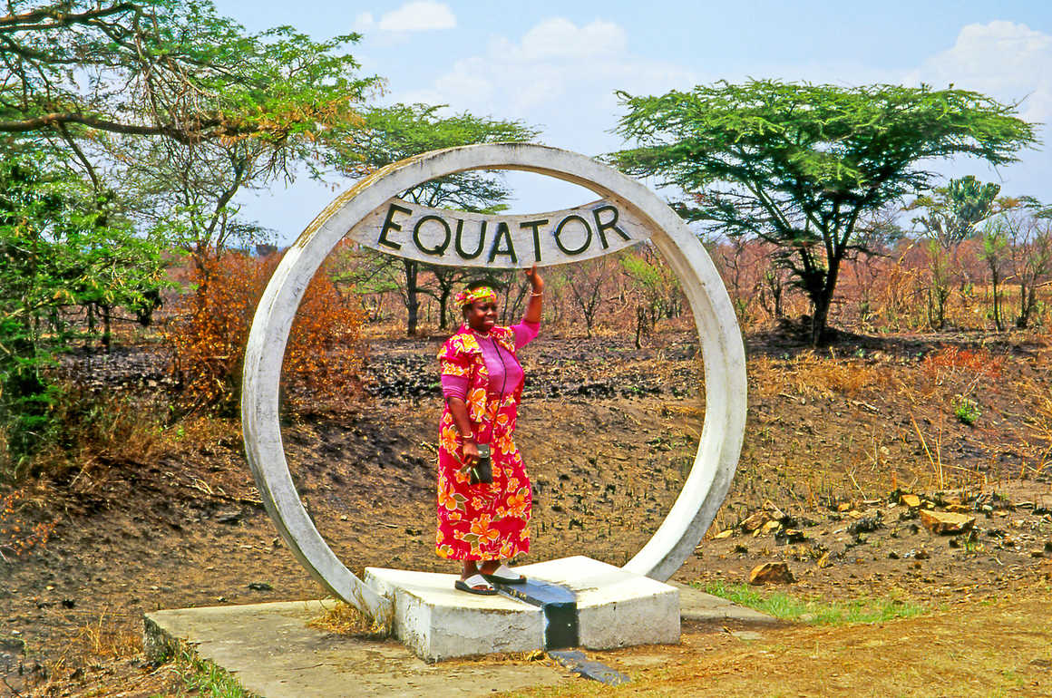 Woman at the equator marker in Uganda