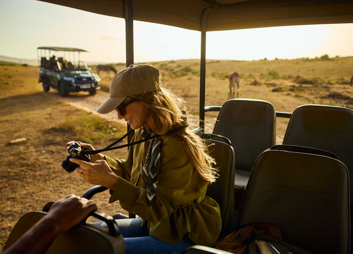 Woman photographing wildlife during safari game drive