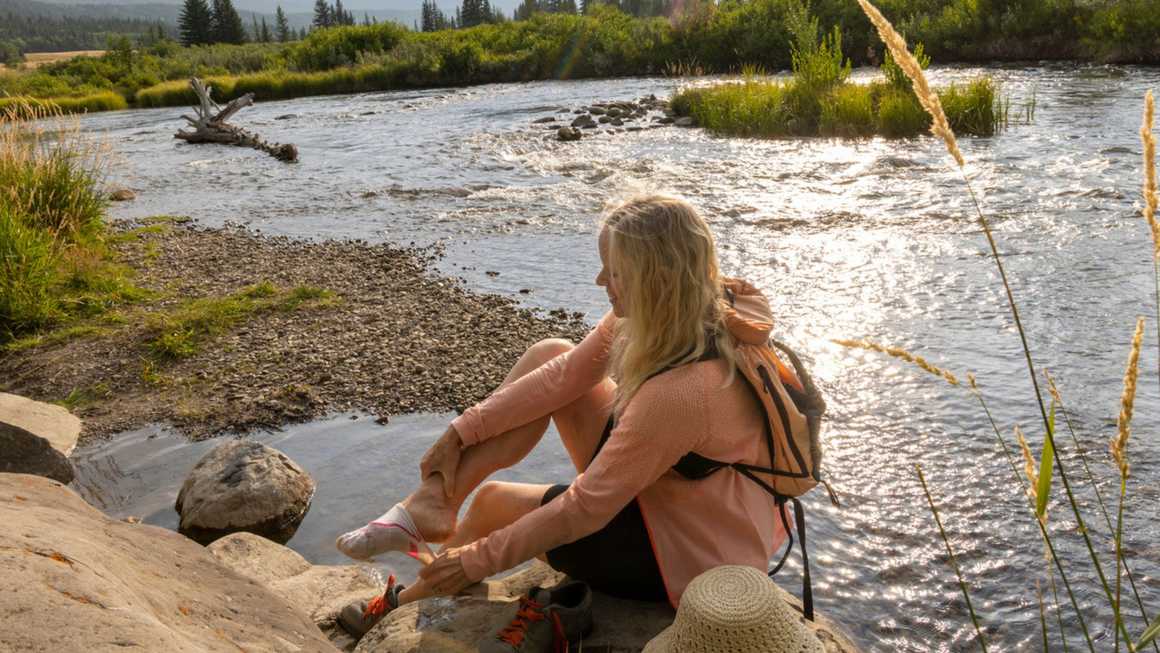 Woman taking off hiking sock