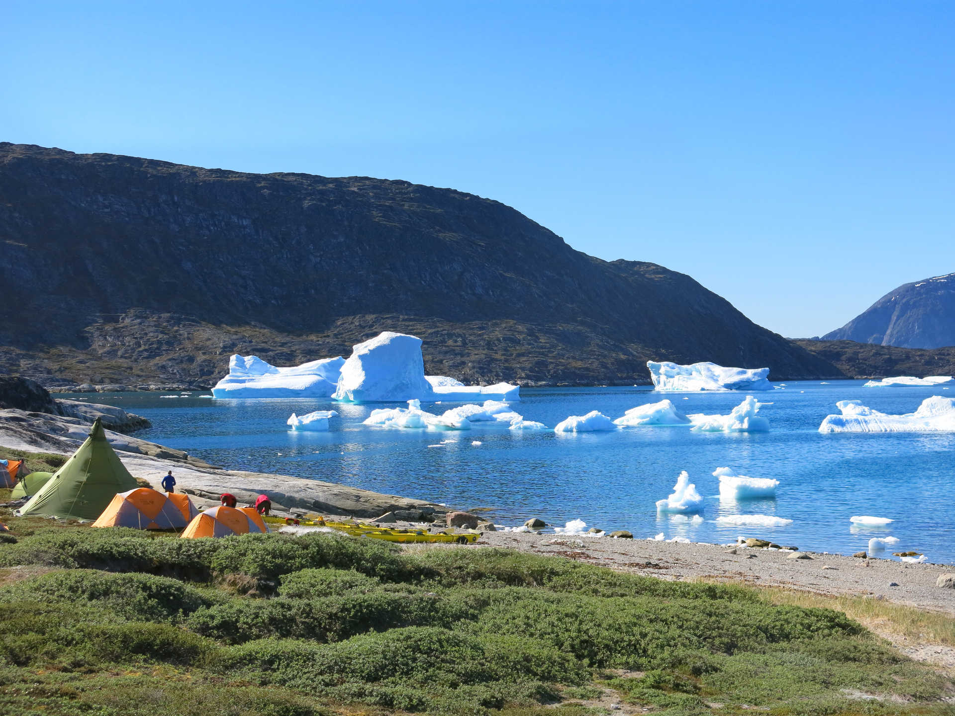 Camp on the coast of Greenland in front of icebergs