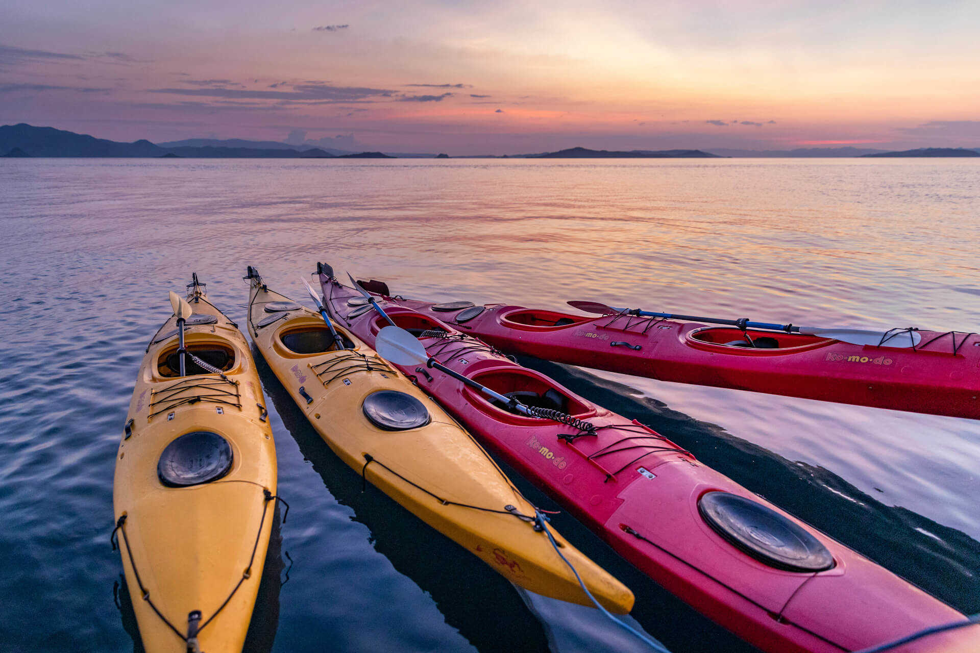 Komodo,Indonesia, colorful Kayaks bound together on the ocean at sunset