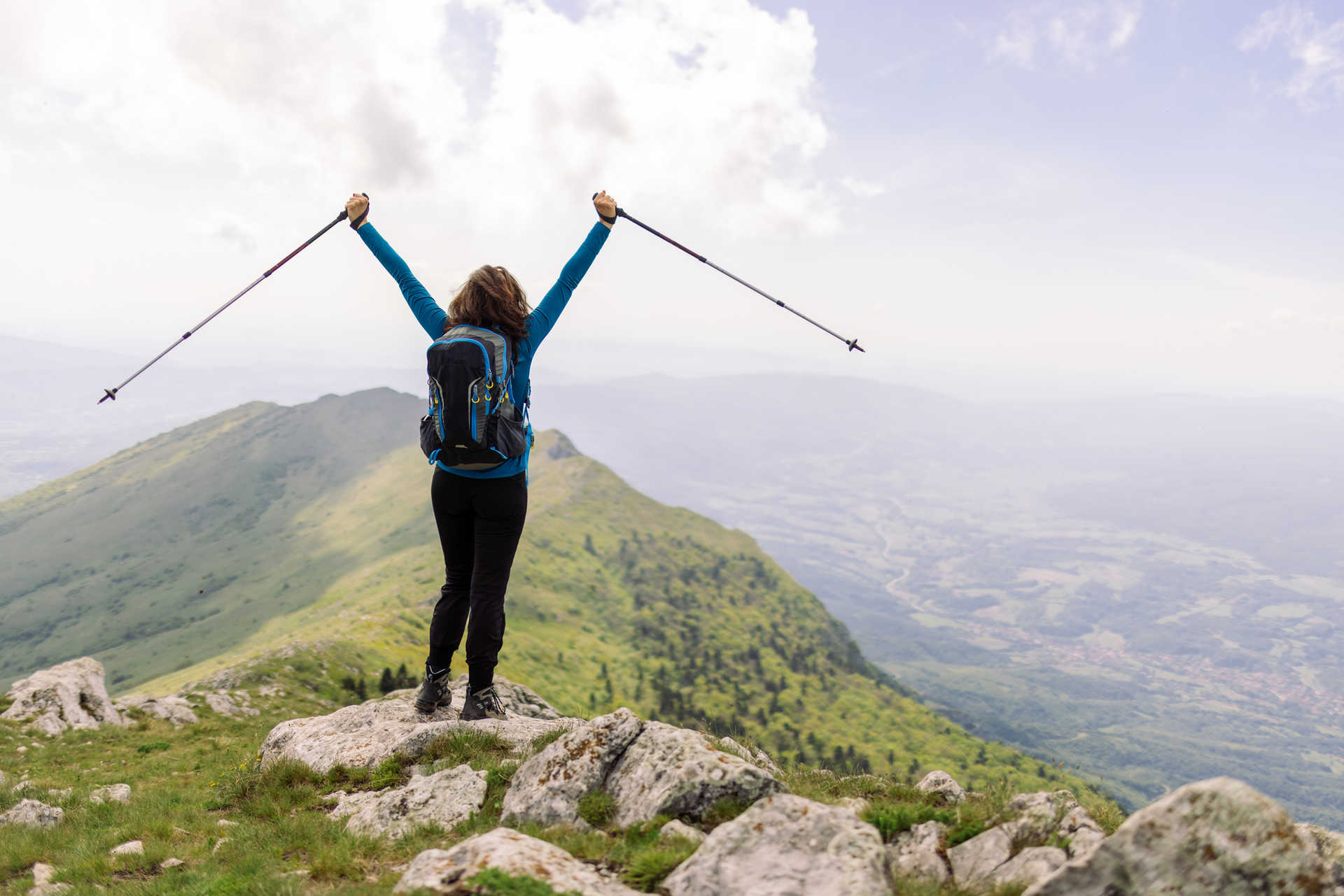 Woman on ridge with trekking poles