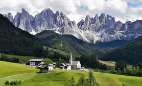 Church in an alpine meadow surrounded by forest and mountains