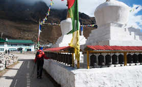 Hiker touching prayer wheels in the Everest region