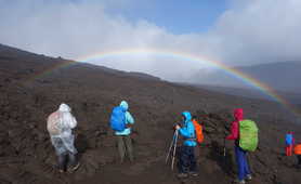 Hikers enjoying a rainbow during the Piton de la Fournaise acsent