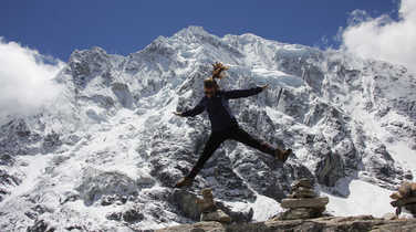 Hiker jumping in front of the Salkantay glacier