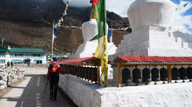 Hiker touching prayer wheels in the Everest region