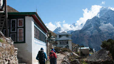 Hikers crossing a village in the Everest region