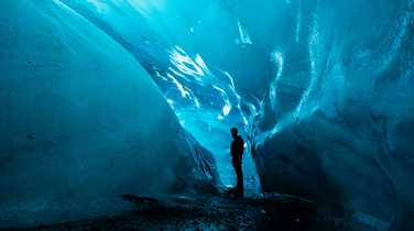 Man standing in an ice cave in Vatnajökull National Park