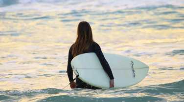 Surfing Woman With Surfboard Going To Surf In Ocean