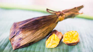 Traditional dish of fish wrapped in banana leaves served with cassava