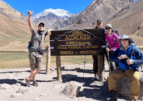 Kandoo hikers posing by the Cerro Aconcagua sign