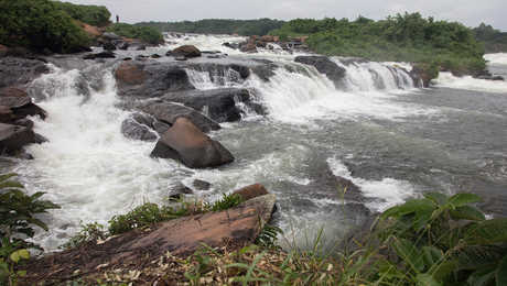 Water falls across rocks in the River Nile in Uganda