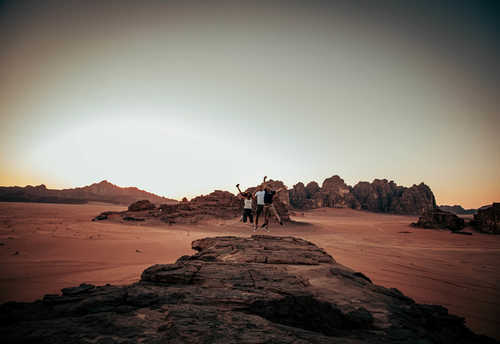 people jumping in the wadi rum desert